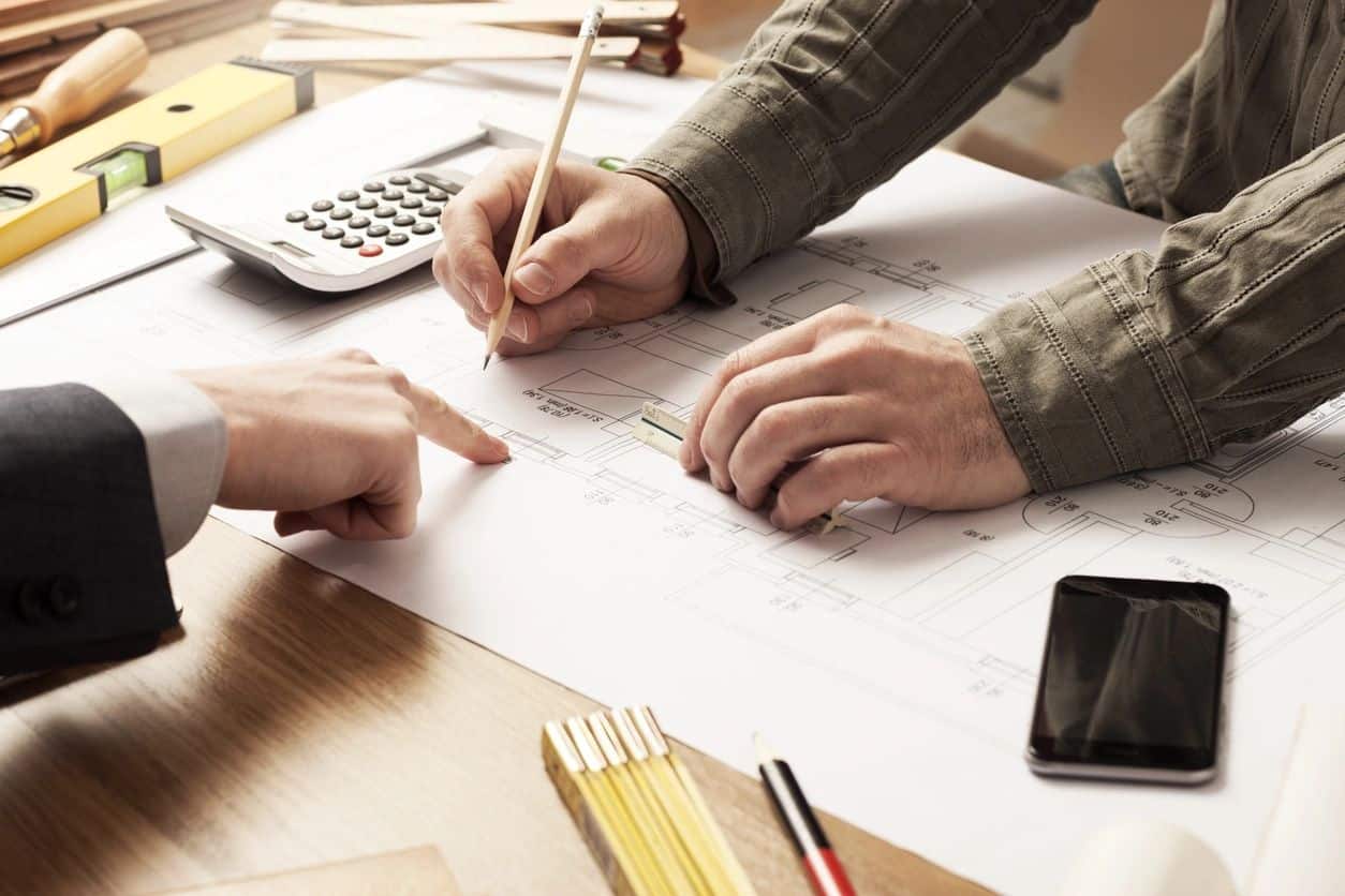 Business owners drafting a credit and collections policy with a calculator and notebook