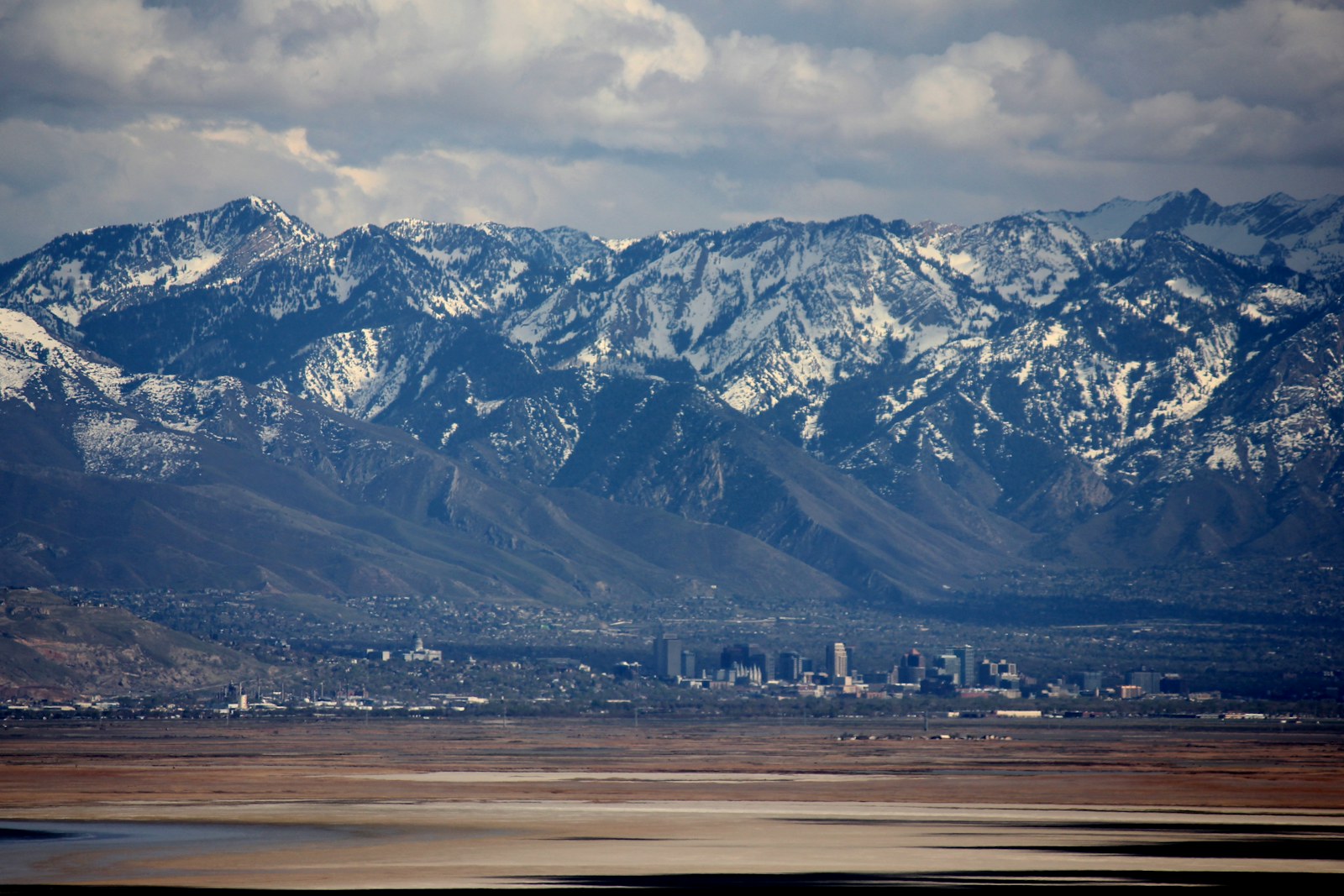 The snow covered Wasatch Range rising behind downtown Salt Lake City and the Utah State Capitol, seen across the valley floor, home to the Utah companies whose unpaid accounts this guide is about
