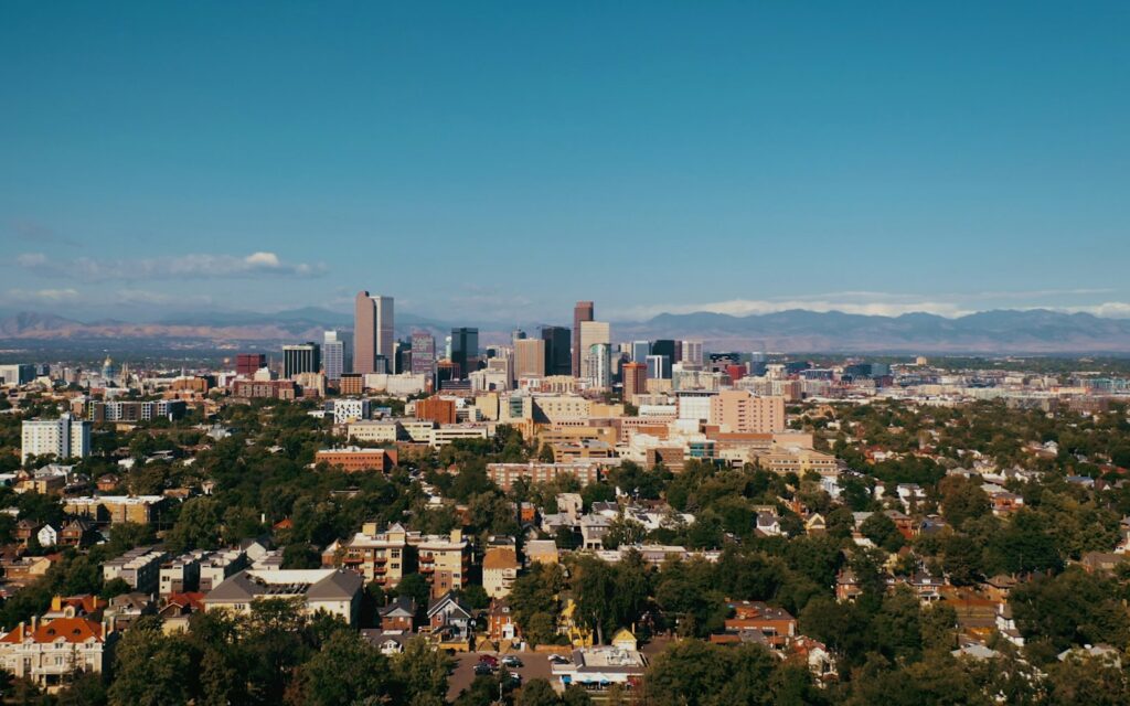 Downtown Denver skyline seen from the east with the Front Range of the Rocky Mountains behind it, the Colorado market where creditors pursue unpaid commercial invoices